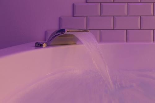 a bathroom sink with water coming from a faucet at Metro Elegance Suites in Tel Binyamin