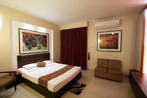 een hotelkamer met een bed en een stoel bij Resort Atlantis 