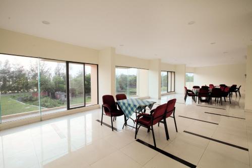 a dining room with a table and chairs and windows at Hotel Orchid Blue in Ināni