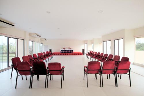 an empty room with red chairs and a table at Hotel Orchid Blue in Ināni