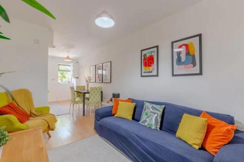 sala de estar con sofá azul y 2 sillas en Bright 2 Bedroom House in Kennington en Londres