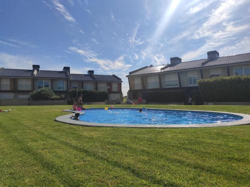 a child playing in a pool in a yard at Sol, mar y naturaleza in Pontevedra