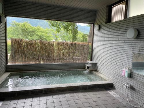 eine Dusche im Bad mit einem großen Fenster in der Unterkunft Togawaso in Fujikawaguchiko