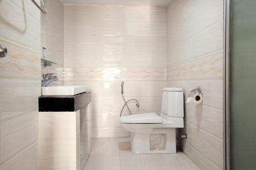 a white bathroom with a toilet and a sink at Hotel Orchid Blue in Ināni