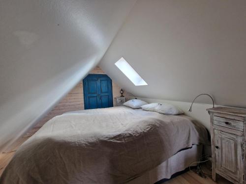 1 dormitorio con 1 cama y puerta azul en Seglarevistet 2, en Domsten