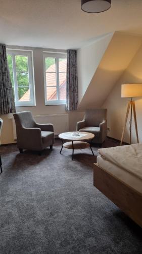 Habitación de hotel con cama, 2 sillas y mesa en Zur Querensteder Mühle, en Bad Zwischenahn