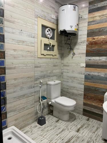 a bathroom with a toilet and a sink and a fan at Modern Apartment 3 room in Sheikh Zayed N5 الشيخ زايد in 6th Of October