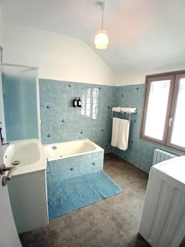 a bathroom with a bath tub and a sink at VILLA CLARETTE in Carhaix-Plouguer