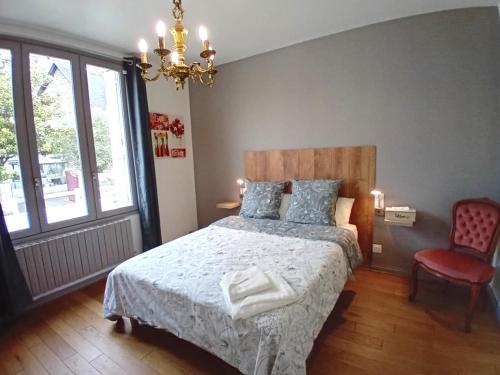1 dormitorio con 1 cama, 1 silla y 1 lámpara de araña en VILLA CLARETTE, en Carhaix-Plouguer
