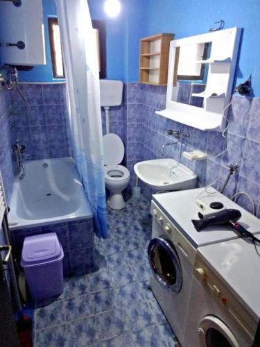 bagno piastrellato blu con lavandino e servizi igienici di Apartman Milica a Foča