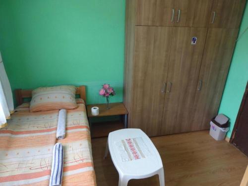 a small bedroom with a bed and a chair at Apartman Milica in Foča