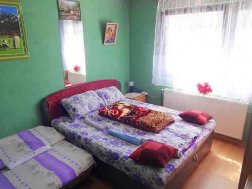 ein kleines Schlafzimmer mit einem Bett mit Kissen darauf in der Unterkunft Apartman Milica in Foča