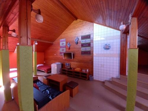Iru的住宿－Urusel Hostel，一间配有沙发、电视和楼梯的客房