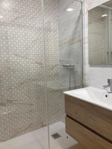 a bathroom with a glass shower and a sink at Apartamento Renovado no Centro da Cidade - Casa4 in Coimbra