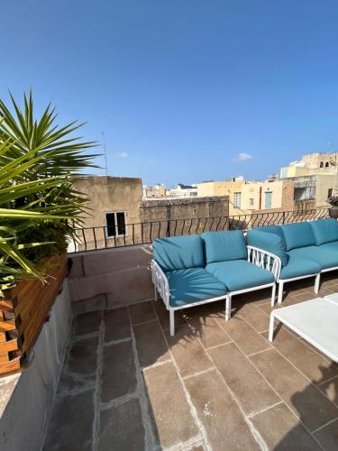 un patio avec deux canapés bleus sur le toit dans l'établissement My Travel House, à Rabat