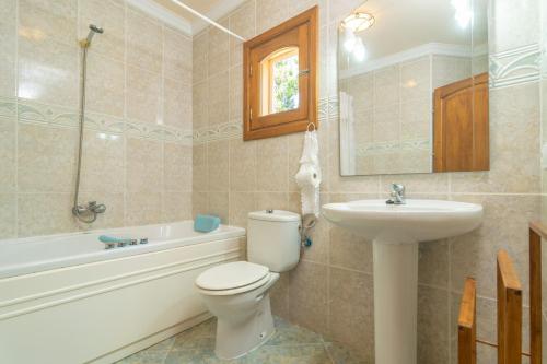 a bathroom with a toilet and a sink and a tub at Villa Son Serra in Son Serra de Marina