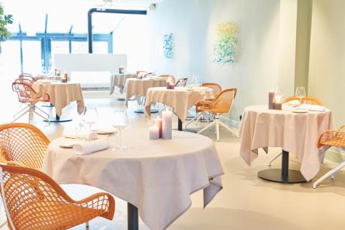 a restaurant with tables and chairs with white table cloths at Relaîs & Châteaux Bij Jef in Den Hoorn