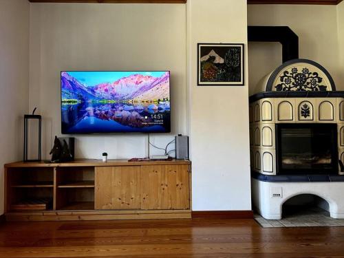 a living room with a flat screen tv on a wall at Lussuoso Chalet in centro a 4 min a piedi dalle piste da sci in Tarvisio