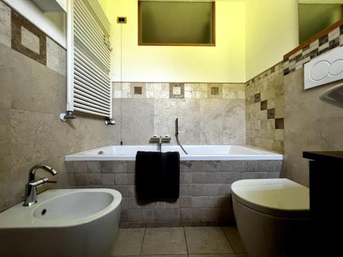 a bathroom with a tub and a toilet and a sink at Lussuoso Chalet in centro a 4 min a piedi dalle piste da sci in Tarvisio