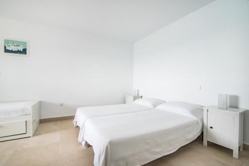 biała sypialnia z 2 łóżkami i 2 stolikami nocnymi w obiekcie Casa Daura Playa de Arinaga 2023 Reformed w mieście Arinaga