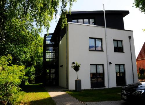 a white house with a tree in front of it at Hotel Blankenese in Hamburg