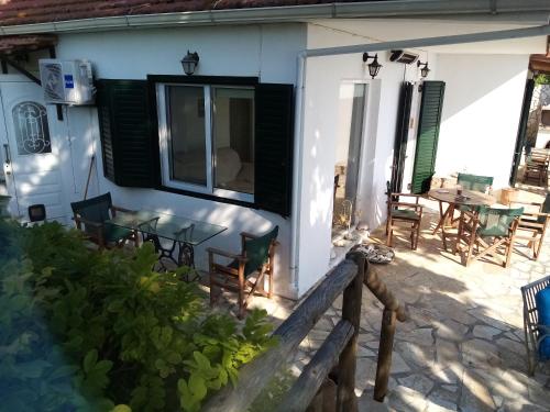 a patio of a house with a table and chairs at Driftwood Villa in Tragaki
