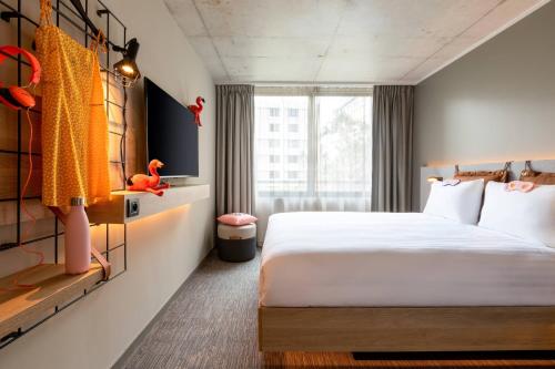 una camera d'albergo con letto e finestra di Moxy Bordeaux a Bordeaux