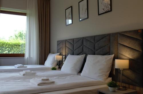 a bedroom with two beds with white pillows and a window at Villa & Gospoda Krakowska in Kobiernice