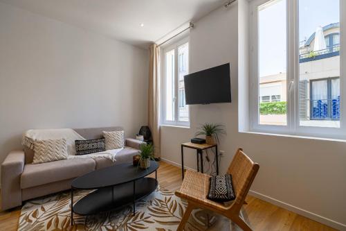 ein Wohnzimmer mit einem Sofa und einem TV in der Unterkunft Nice decorated apartment - near Croisette - 1BR4p in Cannes