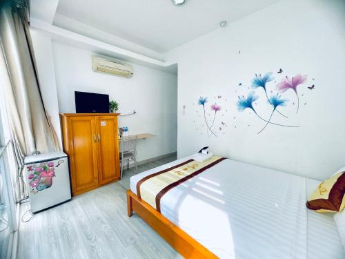 1 dormitorio con 1 cama con flores en la pared en Marieline Hotel Pham Ngu Lao, en Ho Chi Minh