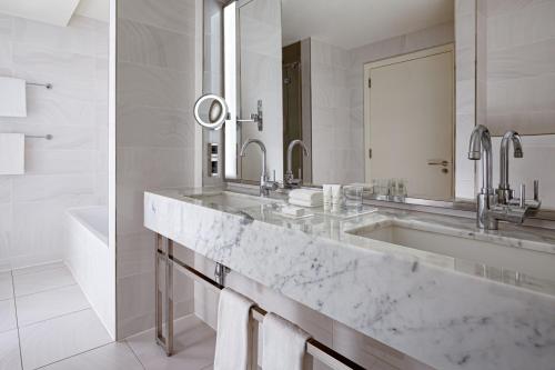 a bathroom with a large marble sink and a tub at Baku Marriott Hotel Boulevard in Baku