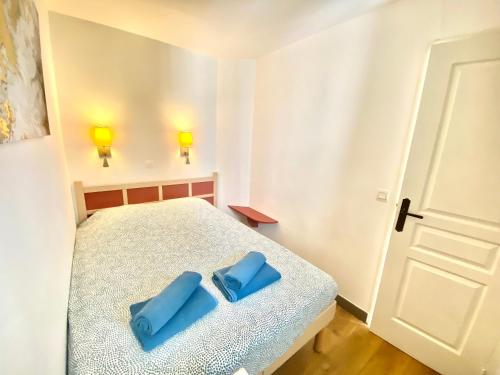 une chambre avec un lit avec des oreillers bleus dessus dans l'établissement Les Ingres By SCLS Locations, à Cannes