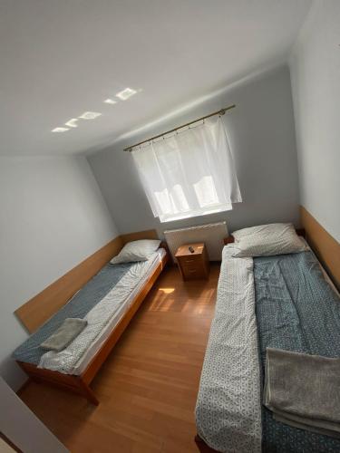 a bedroom with two beds and a window at "U Jędrusia" in Żychlin