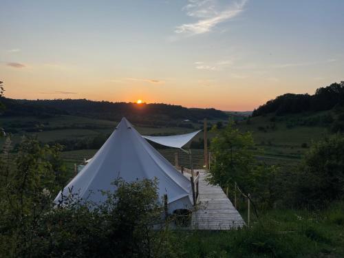 a marquee in a field with the sunset in the background at Bell View 