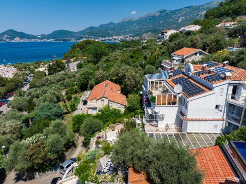 an aerial view of a house on a hill next to the water at Sun Rose Apartments Sveti Stefan in Sveti Stefan