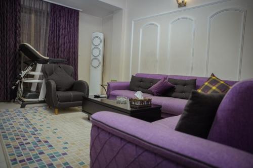 a living room with purple furniture and a purple couch at فندق البيت الصغير - Lapetite Maison Hotel in Baghdad