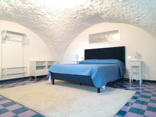 1 dormitorio con 1 cama azul en una habitación blanca en Sea Breeze House, en Amalfi