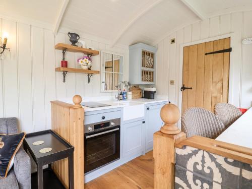a kitchen with white cabinets and a table and chairs at Utopia in Harleston