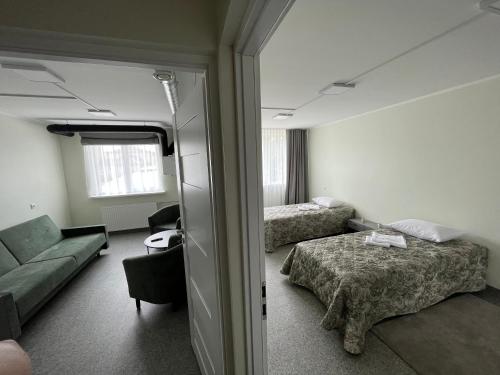 pokój hotelowy z 2 łóżkami i kanapą w obiekcie VESK Veisiejai w mieście Veisiejai