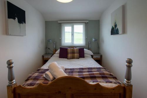 1 dormitorio con 1 cama con manta y ventana en Lily pad Lodge en Rous Lench