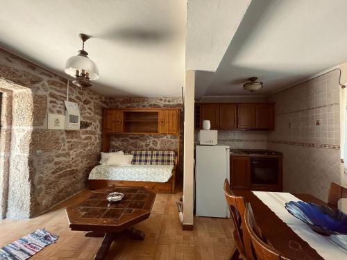 a kitchen with a room with a bed and a refrigerator at Quinta Do Moinho Turismo de Natureza in Aldeia Viçosa