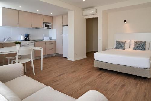 een klein appartement met een bed en een keuken bij LEGACY SUITES & APARTMENTS ALBUFEIRA AL in Albufeira