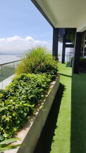 a row of green bushes in front of a building at Urban Suites Jsw in Jelutong