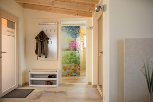a hallway with a closet with a coat hanging on the wall at Feriendorf Waidlerland in Mauth