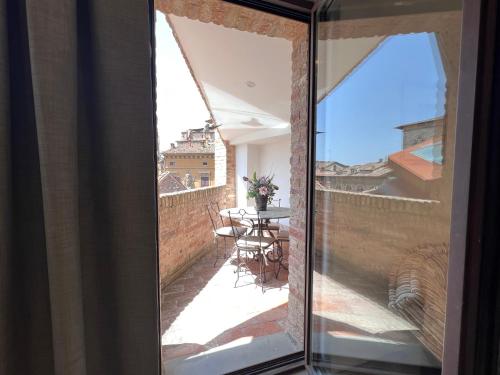 a glass window of a balcony with a table at Il Terrazzo di Tolomei in Siena