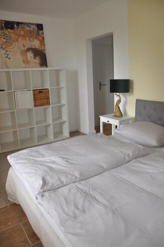 een groot wit bed in een kamer met een lamp bij 2-Zimmer Studio mit Terrasse und Fernblick - Marburg in Marburg an der Lahn