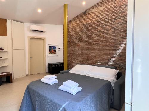 a bedroom with a bed and a brick wall at Il Terrazzo di Tolomei in Siena