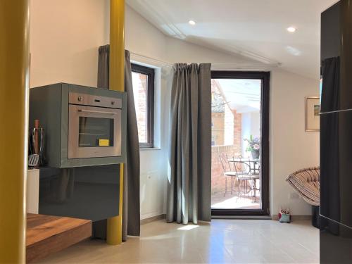 a kitchen with a microwave and a door to a patio at Il Terrazzo di Tolomei in Siena