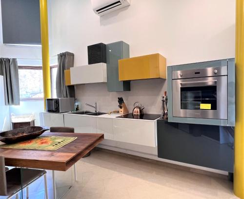 a kitchen with stainless steel appliances and a wooden table at Il Terrazzo di Tolomei in Siena