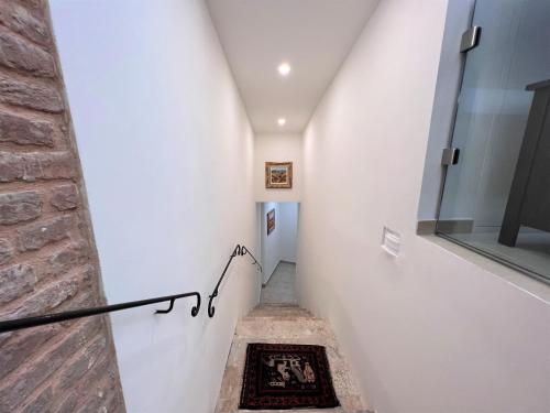 a staircase in a house with white walls and a brick wall at Il Terrazzo di Tolomei in Siena